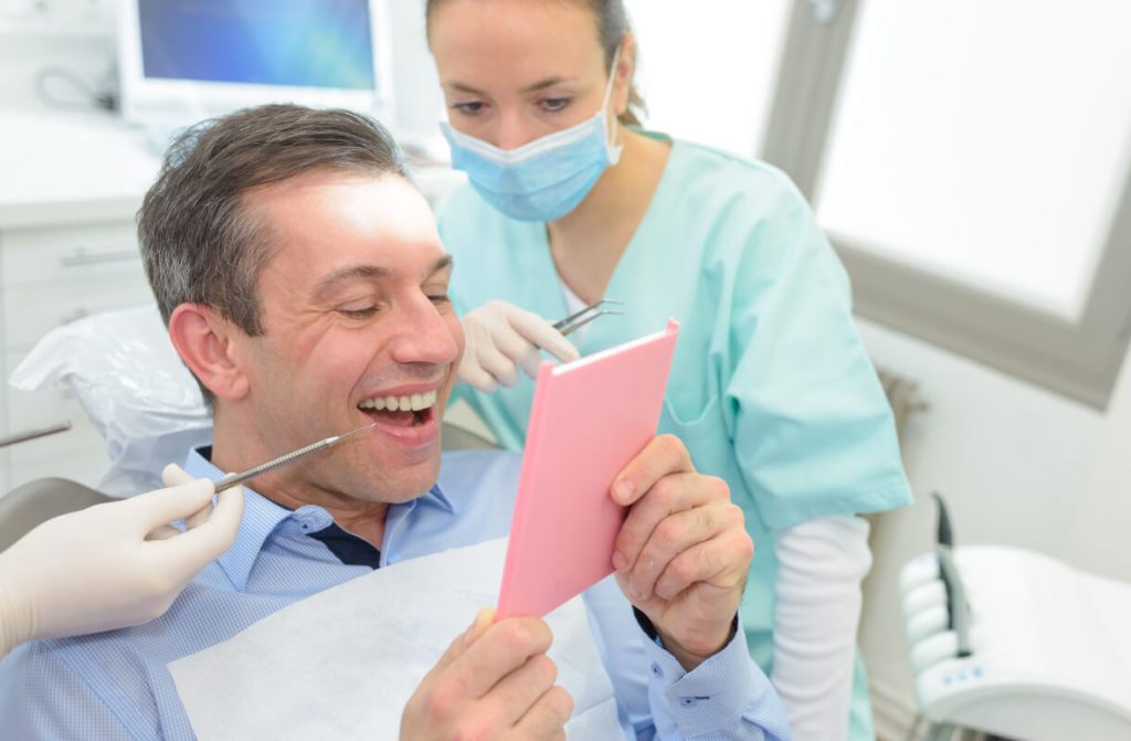 man looking at his smile at the dentist