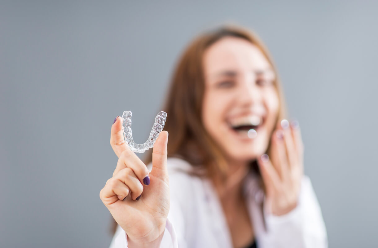 woman holding her Invisalign tray